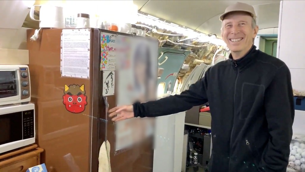 冷蔵庫の前で笑うブルースさん